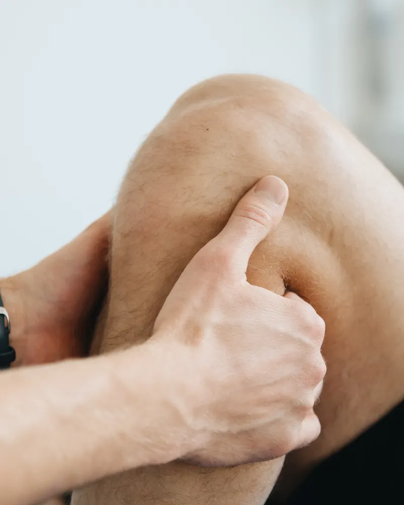 Therapist applying hands-on treatment around a client's knee