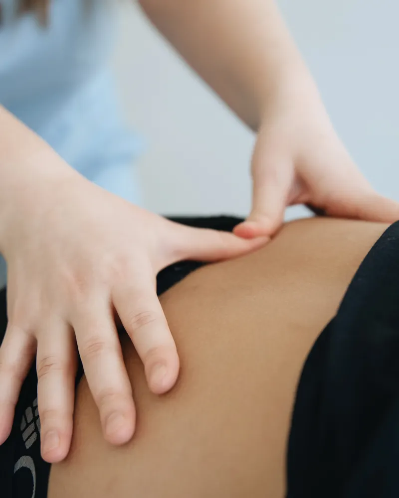 Therapist applying deep tissue massage to a client's lower back