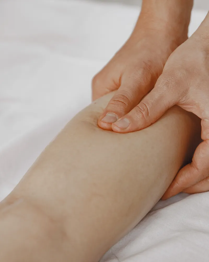 Hands applying targeted pressure during lower-leg massage treatment